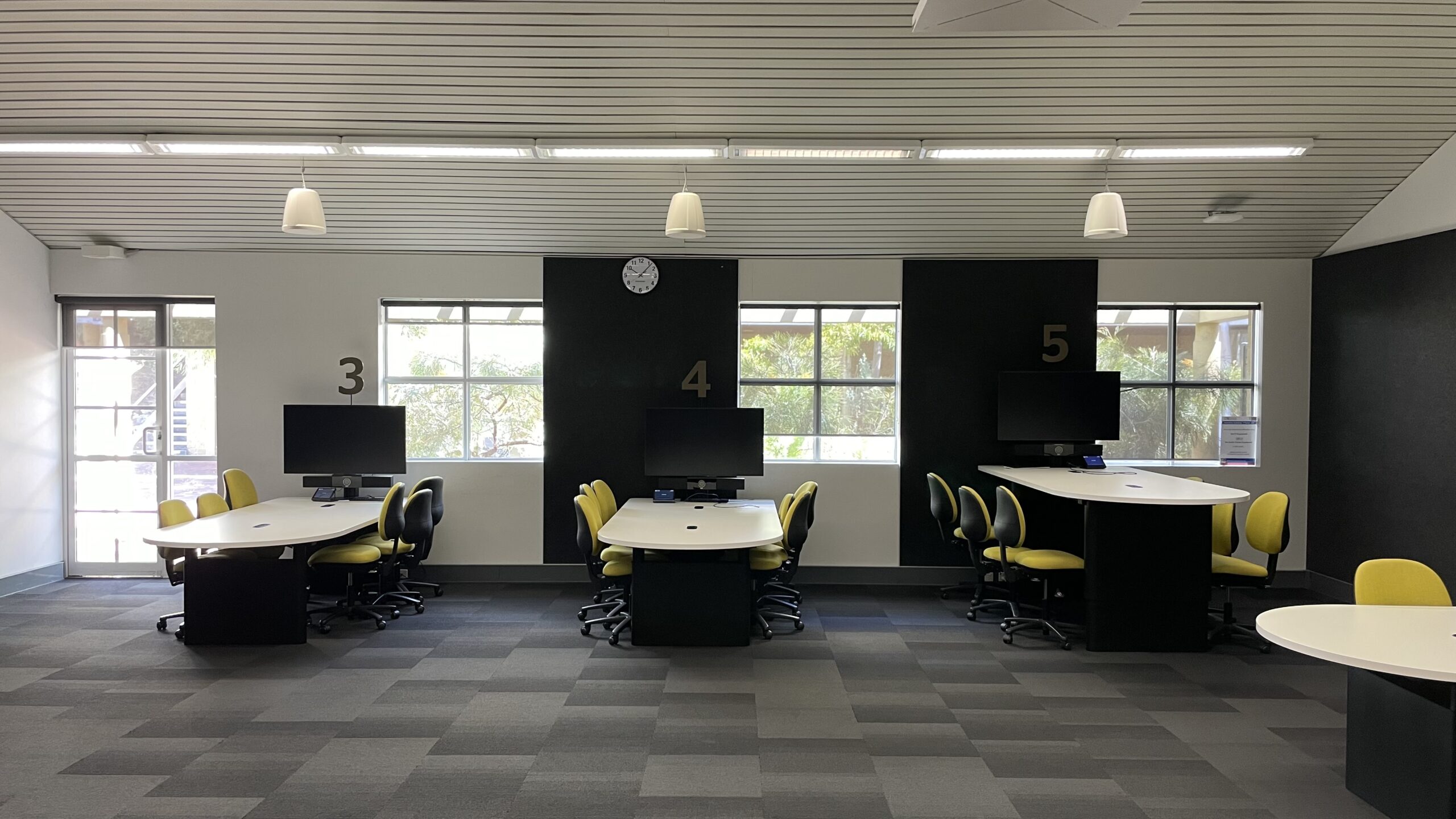 ECU's pilot digital learning classroom, featuring student pod screens, student participation control panels, overhead microphones and speakers. The student control panels allow collaboration, sharing, and active learning and position students to have an active role in their learning.